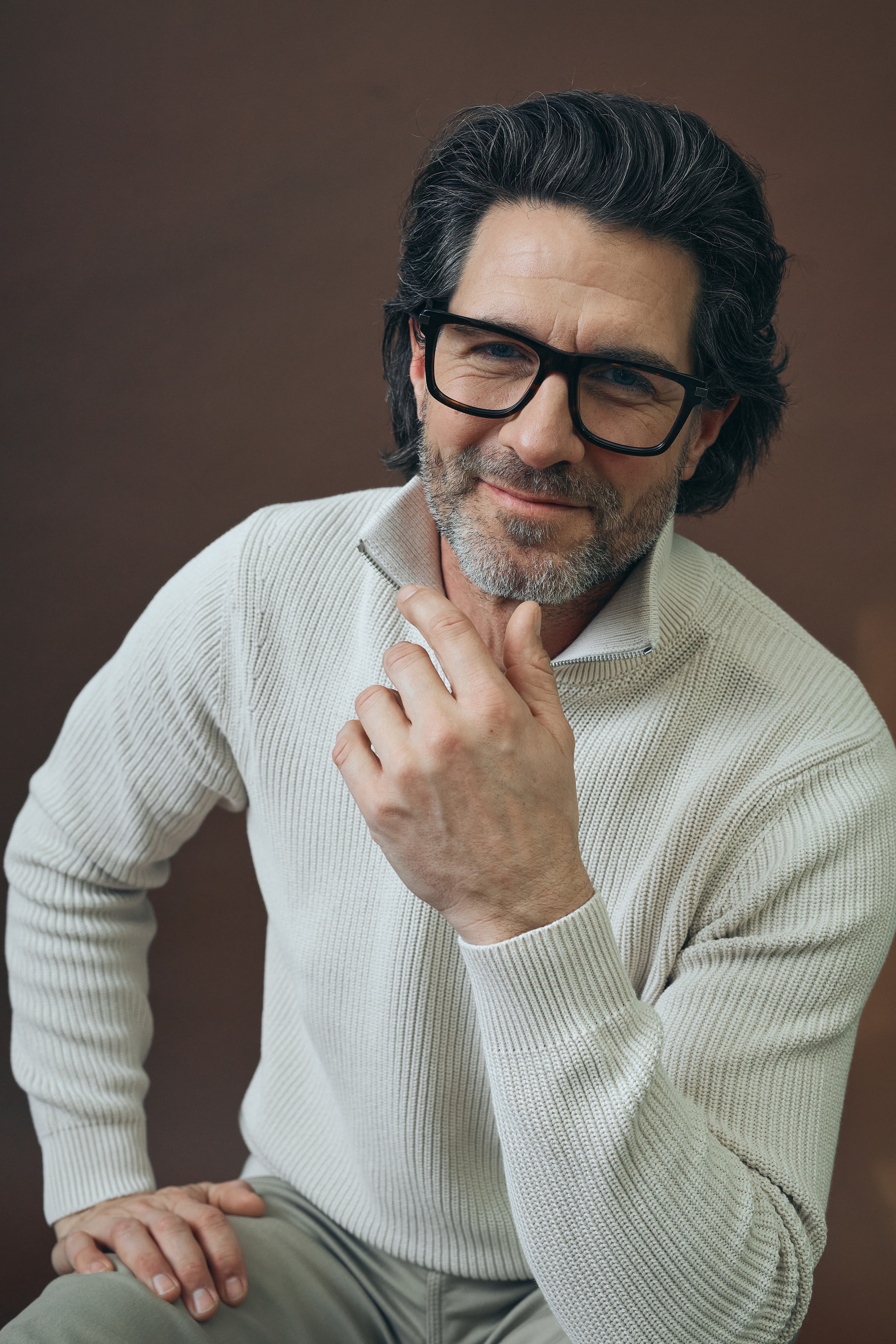 Mann mit schwarzer korrektionsbrille und beigen pullover